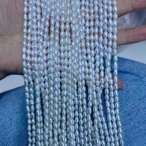 Close-up of 3mm high luster freshwater rice pearl strands, premium pearl beads for custom jewelry design, artisan studios, and DIY craft stores.