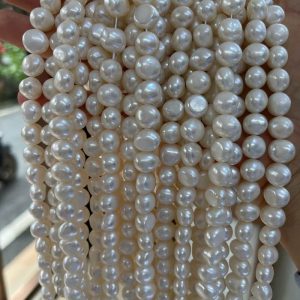 Close-up shot of natural white nugget-shaped freshwater pearls showcasing high luster and organic surfaces.