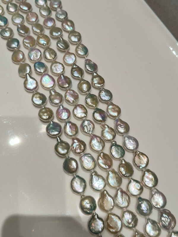 strands of uniform 13mm flat coin pearls with exceptional metallic luster, ideal for matching earring pairs.
