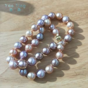 Caliper measuring a 9-11mm near-round multicolor Edison pearl necklace with vibrant metallic luster.