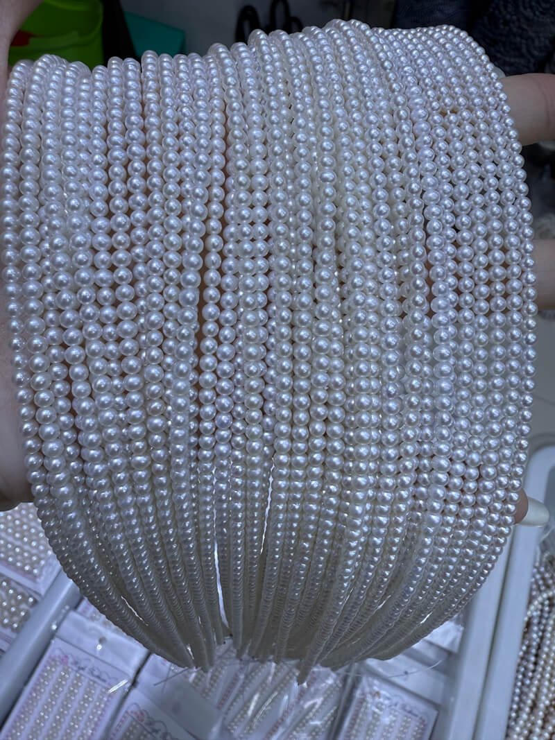 Wholesale 2.75-3mm white near-round seed pearl strands for delicate June birthstone necklace designs.