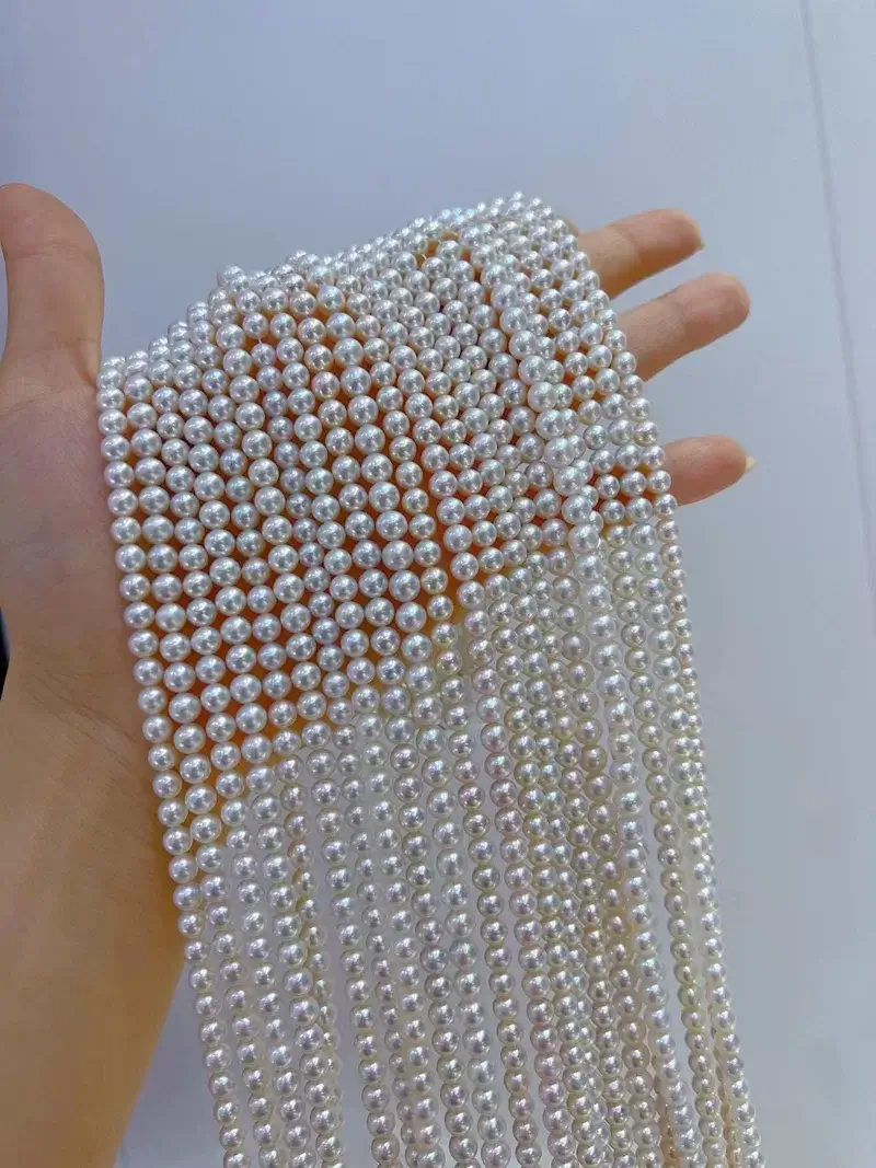 Multiple 16-inch strands of 5mm natural white freshwater round pearls, loose and ready for jewelry making.