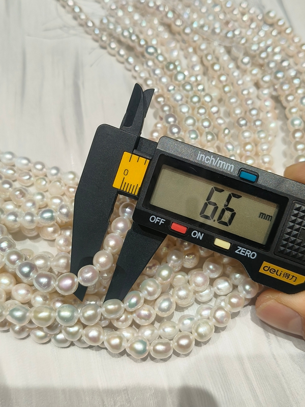 Digital caliper showing 6.6mm near-round nugget cultured pearls, ideal loose bead supplies for statement bridal jewelry and fashion necklaces.