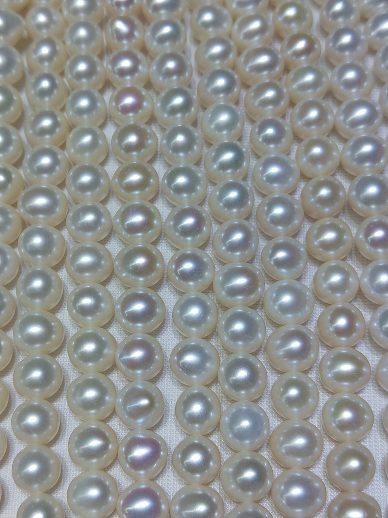 Wholesale B2B supplier showcasing multiple strands of premium 9-10mm high luster potato freshwater pearls.