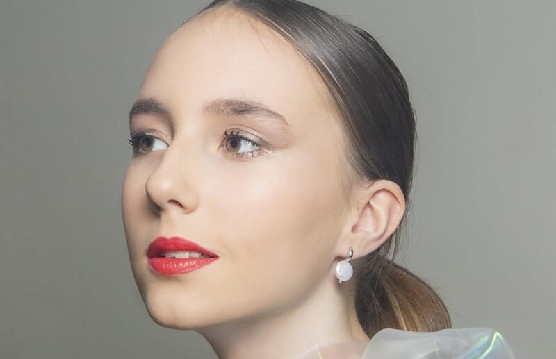 Model wearing elegant wholesale large white baroque freshwater pearl drop earrings showcasing premium luster for bridal or boutique jewelry.