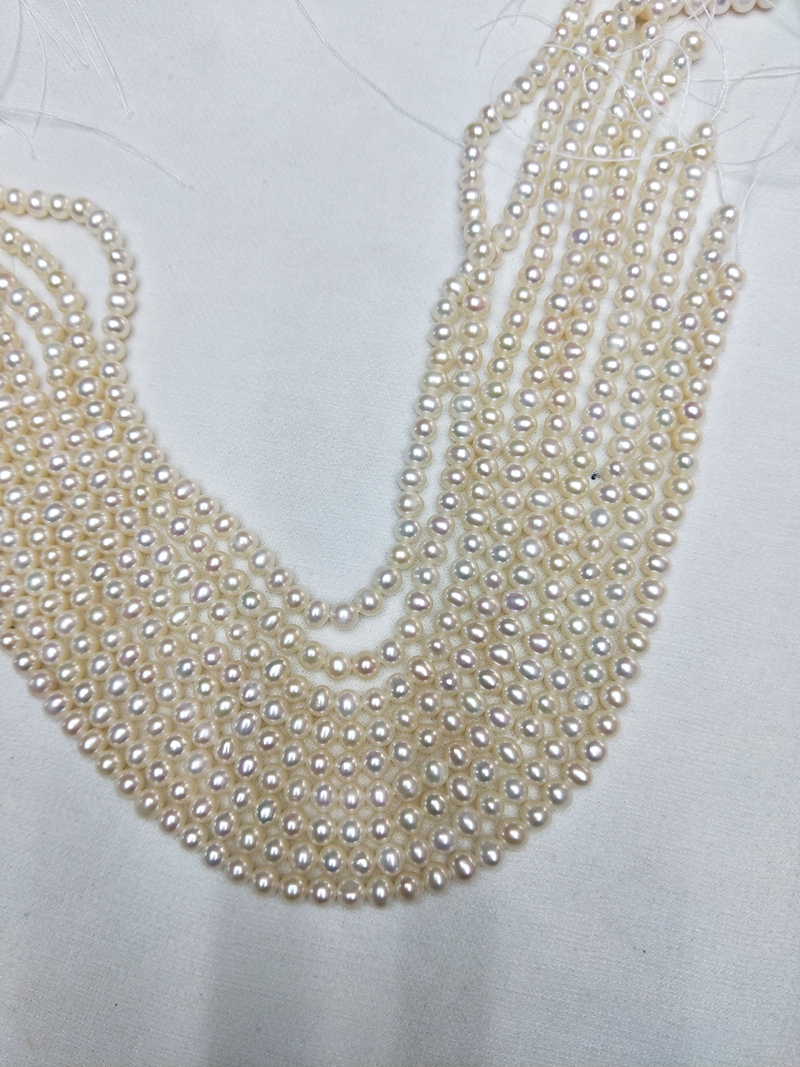 Close-up of 5mm semi-round natural white freshwater pearls with high luster for bridal jewelry