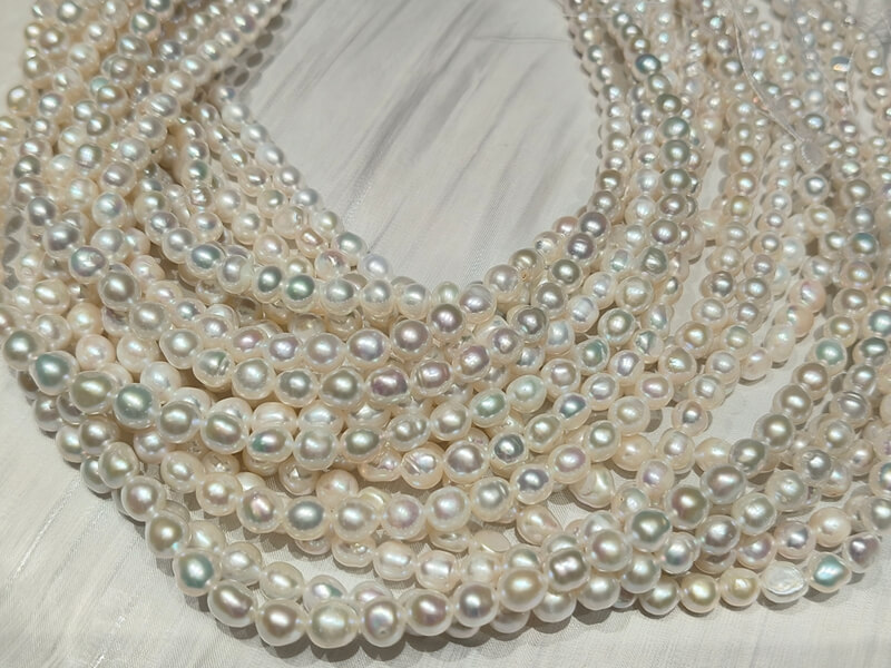 Close-up of premium nugget shape baroque pearls with metallic rainbow luster, perfect for creating unique cultured pearl necklaces.