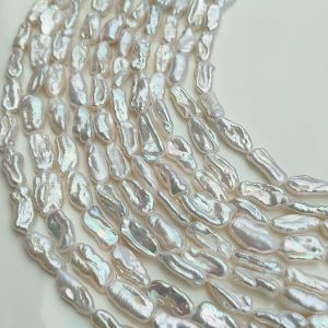 Bulk wholesale strands of natural freshwater stick pearls in white and pastel shades, ready for custom jewelry making.