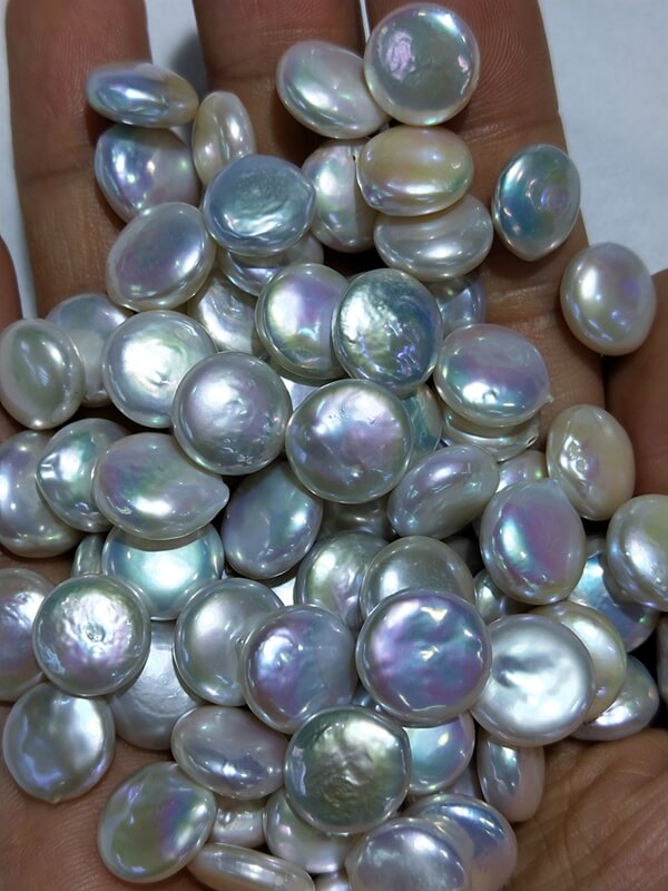 Bulk loose white coin pearl beads in factory inventory for jewelry manufacturers and brands.
