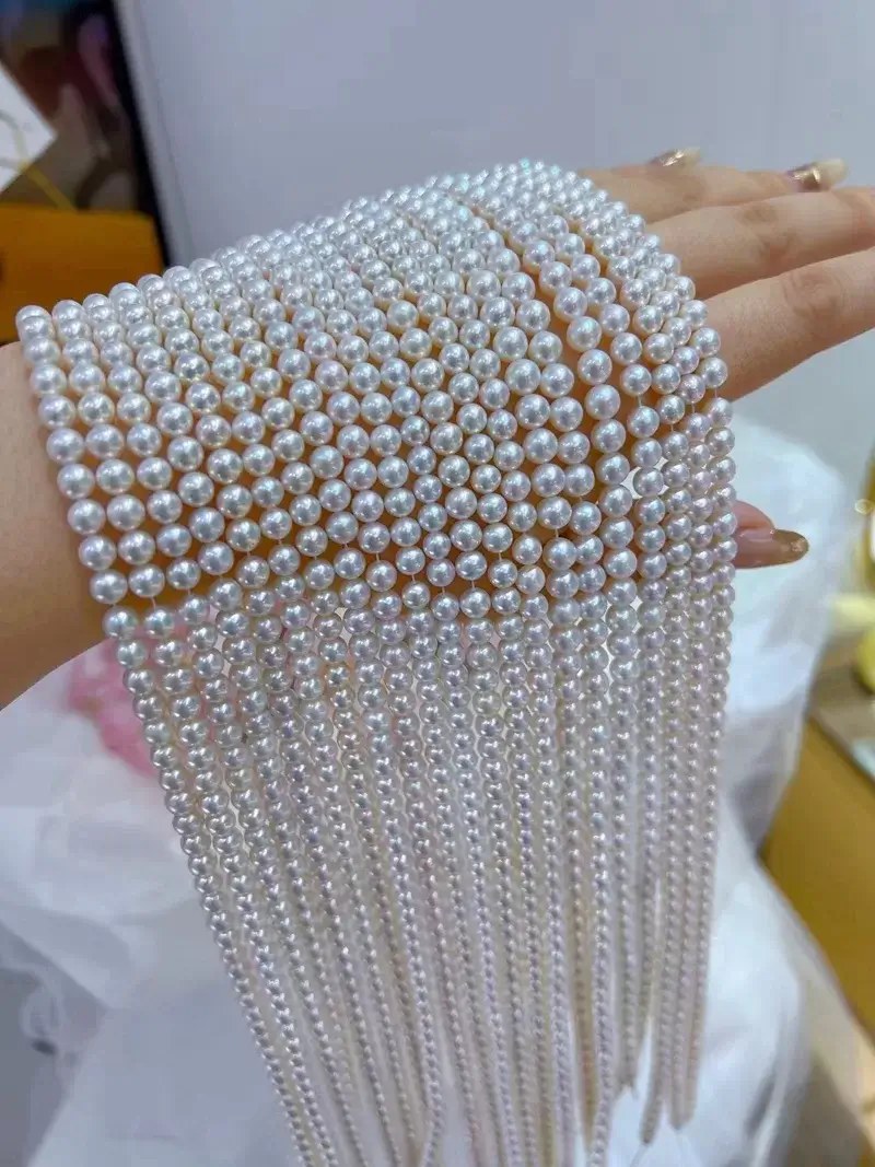 A close-up of 5mm natural white freshwater round pearls, loose and ready for jewelry making, showcasing their high luster.
