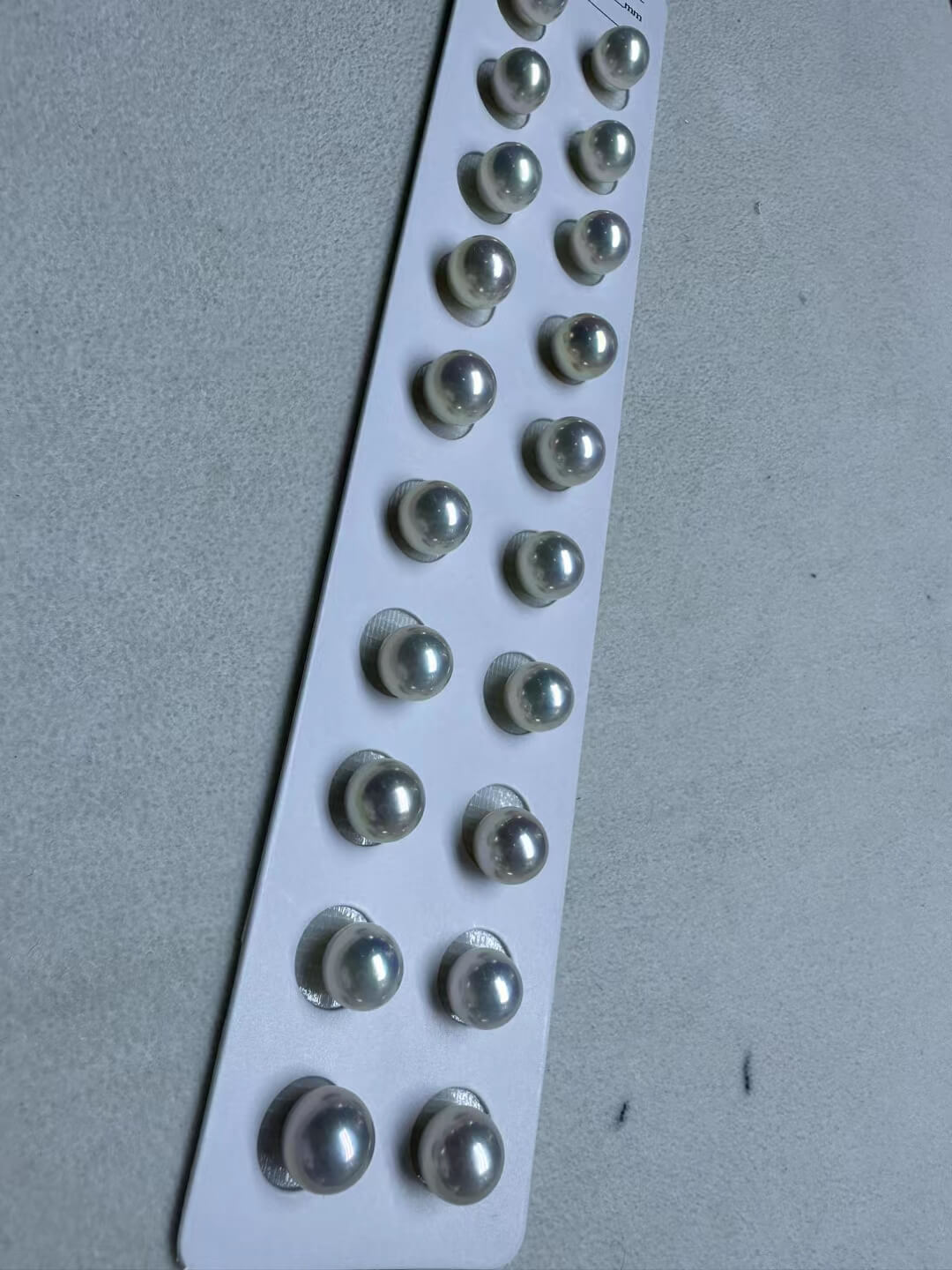 Wholesale loose 9mm round freshwater pearls in a bulk lot for jewelry making.