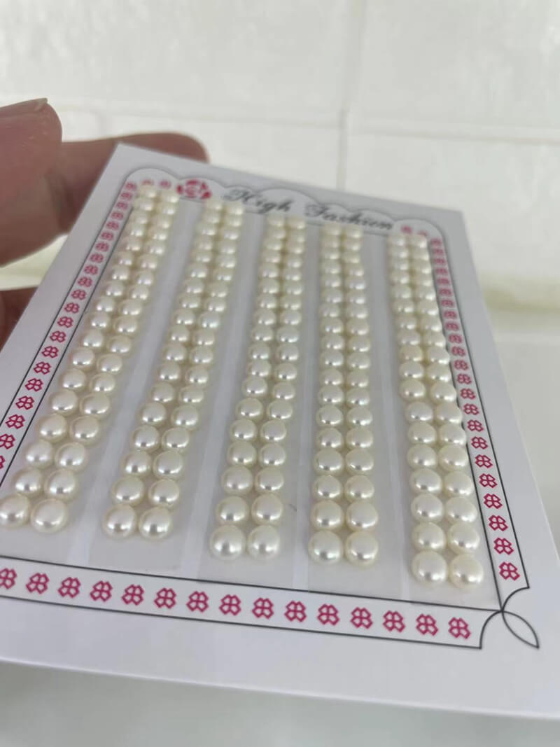 4-5mm loose freshwater button pearls held on hand showing natural white color