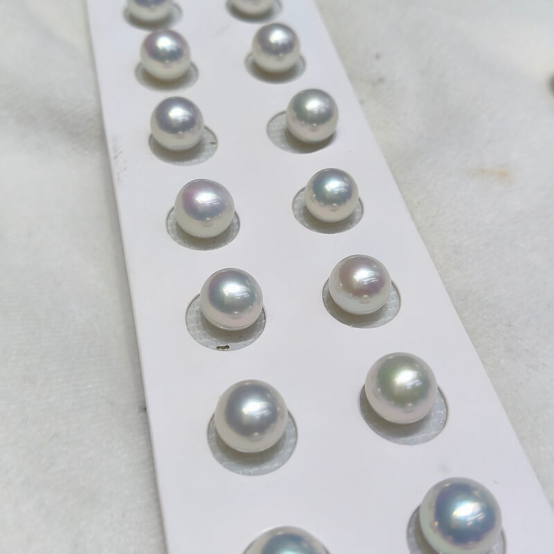 Half-drilled premium freshwater Edison pearl pairs ready for stud earring jewelry making, showcasing a flawless round profile.