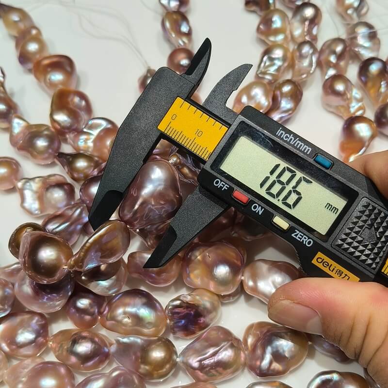 Digital caliper measuring a large 18.6mm genuine metallic purple Edison baroque pearl for purple pearl necklace designs.