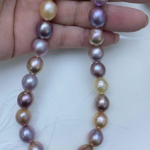 A hand-selected multicolor freshwater baroque pearl strand in natural purple and gold tones for bespoke jewelry designers.