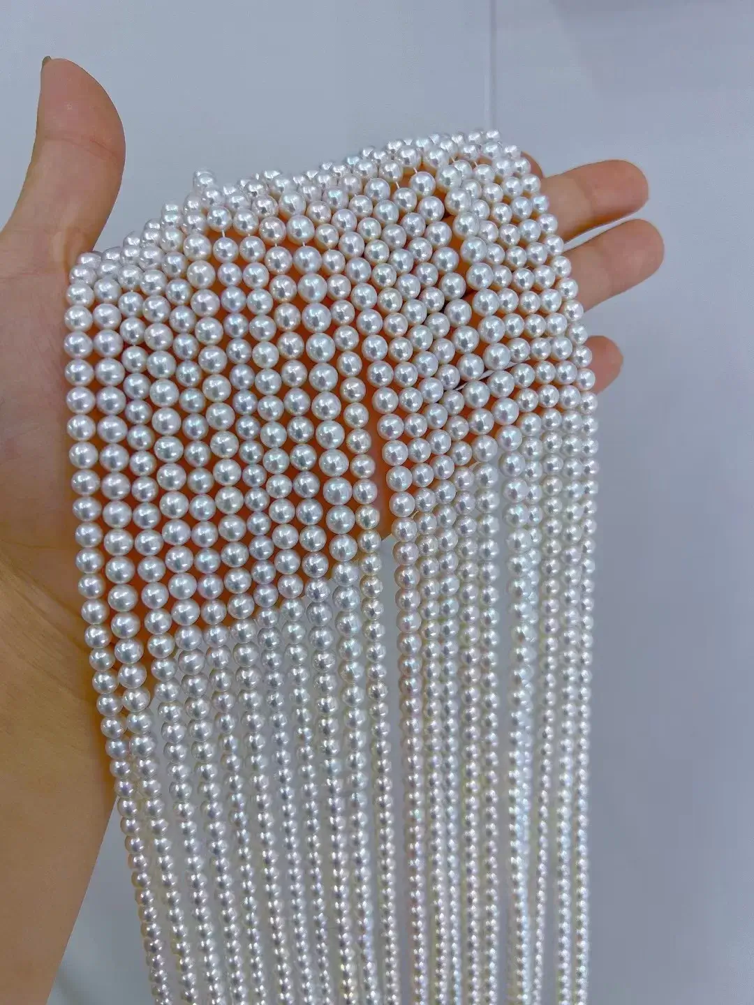 A 16-inch strand of 5mm natural white freshwater round pearls, loose and ready for jewelry making.