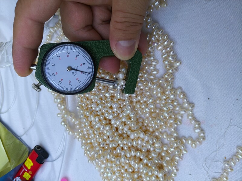 Close-up view of premium side-drilled freshwater rice pearls, highlighting high luster white pearls for unique fringe or tassel jewelry designs.