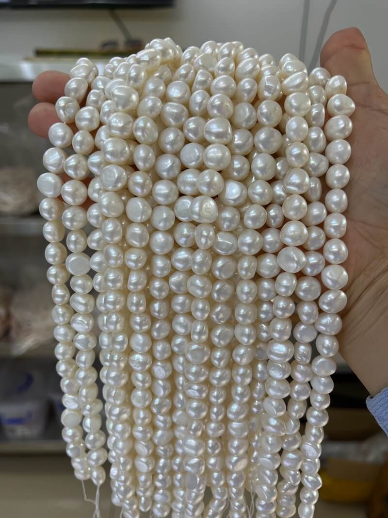 Wholesale B2B supplier displaying premium 10-11mm white baroque nugget pearl strands for jewelry brands.