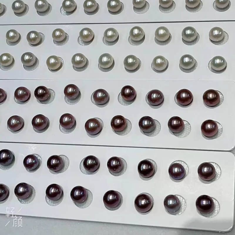 A collection of wholesale Edison pearl pairs side by side, comparing the elegant undyed natural white and rich natural purple shades.