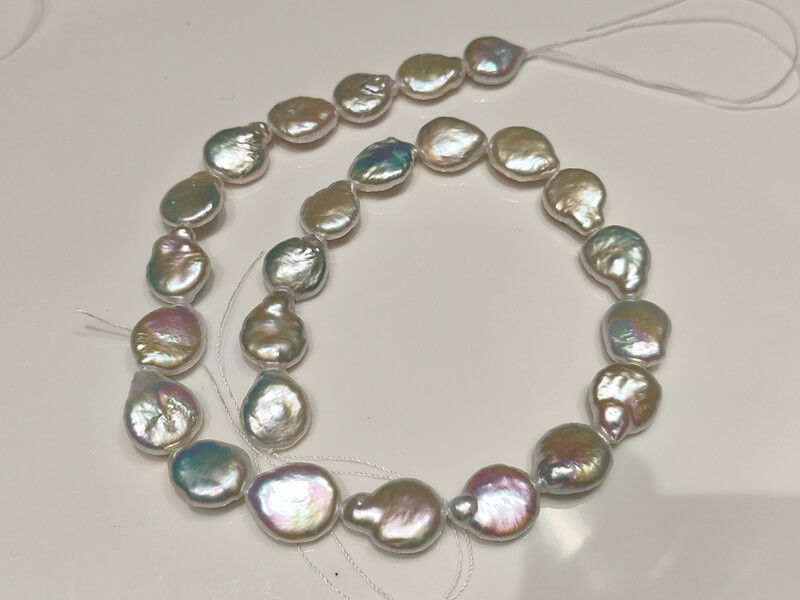 Premium quality freshwater coin pearl strands curved on a white background, perfect for custom designer jewelry.