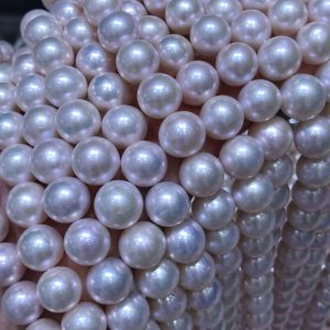 Close-up of near-round 11.0mm-12.0mm nucleated freshwater pearls, showcasing brilliant silver-pink iridescent radiant overtones and clean surfaces.