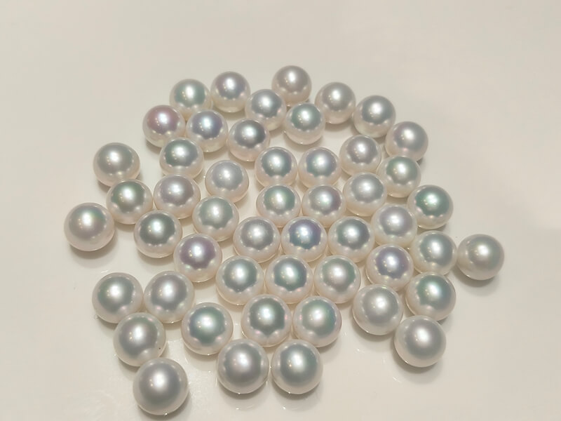 undrilled white Edison round pearl on a white background, demonstrating the precise calibration ideal for setting custom pearl rings.