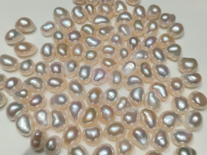 Close-up of top-to-bottom fully drilled bean shaped loose baroque pearls ready for headpins