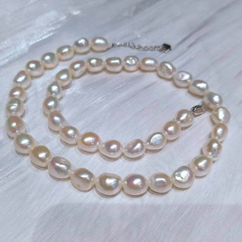 Close-up of a real 10-11mm nugget freshwater pearl necklace with sterling silver clasp, high-quality organic baroque pearls from factory direct wholesale supplier.