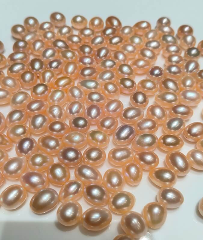 Bulk wholesale of 8.5x11mm peach drop freshwater pearls in symmetrical tear drop shape for jewelry making