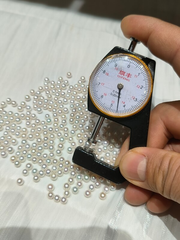 4.5-5mm round white freshwater pearls with half-drilled holes for wholesale quality control.
